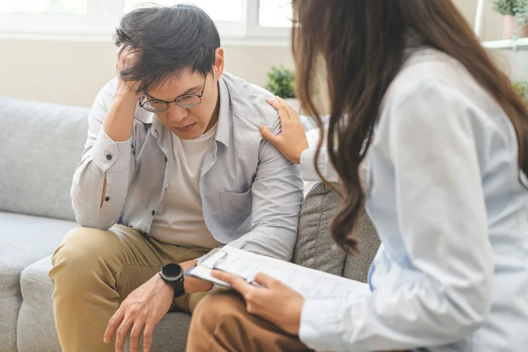 A supportive therapist helping her patient learn how to recover from alcoholism.