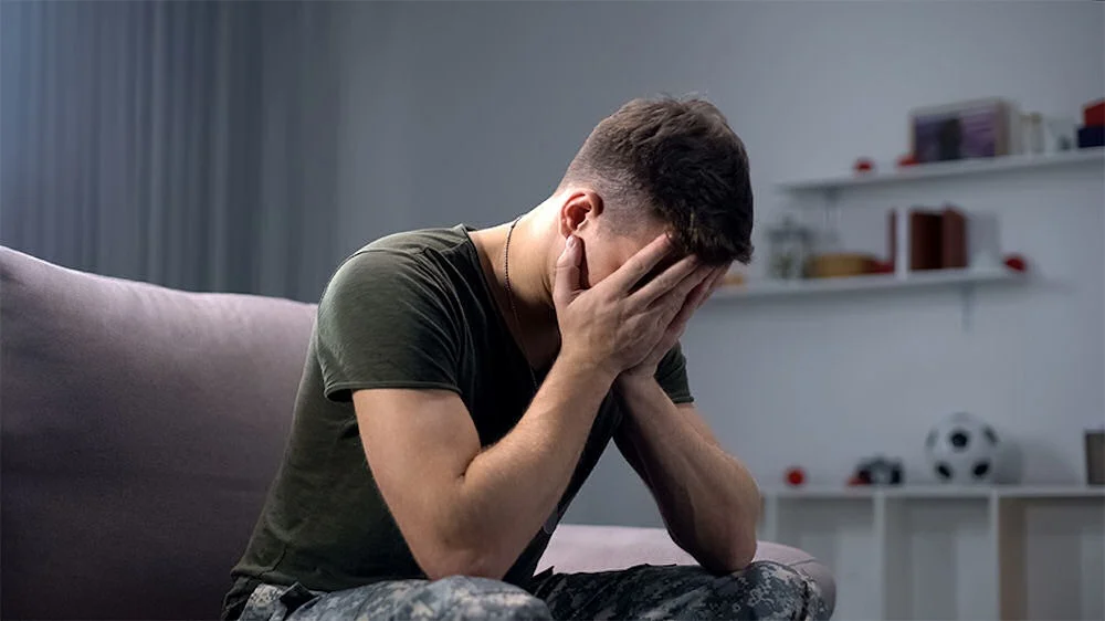 ptsd-night-terrors a veteran with face in hands in therapy