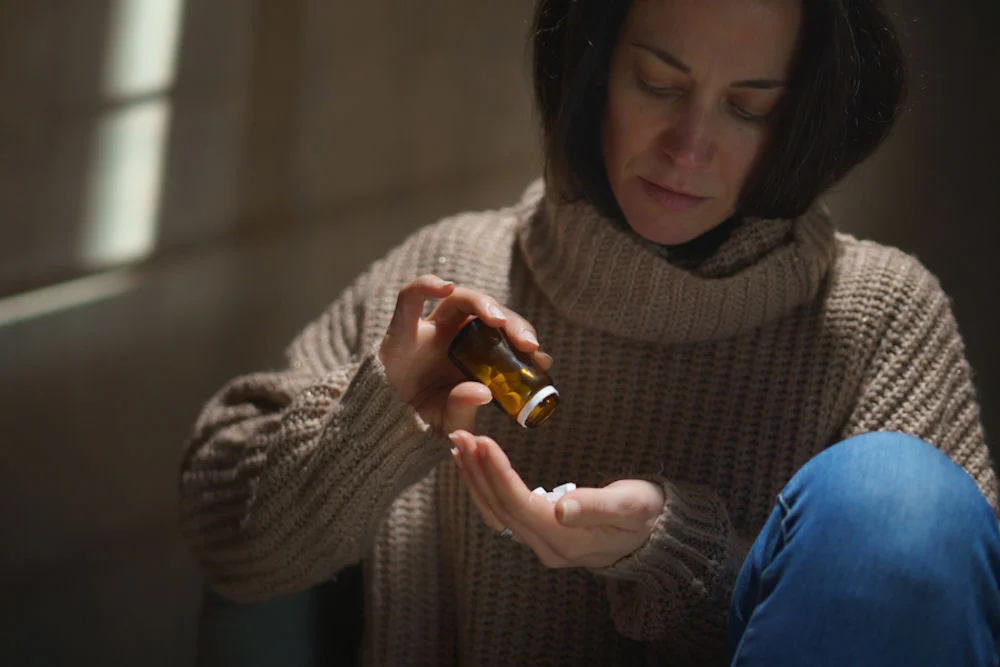 a-woman-pouring-benzos-in-hand
