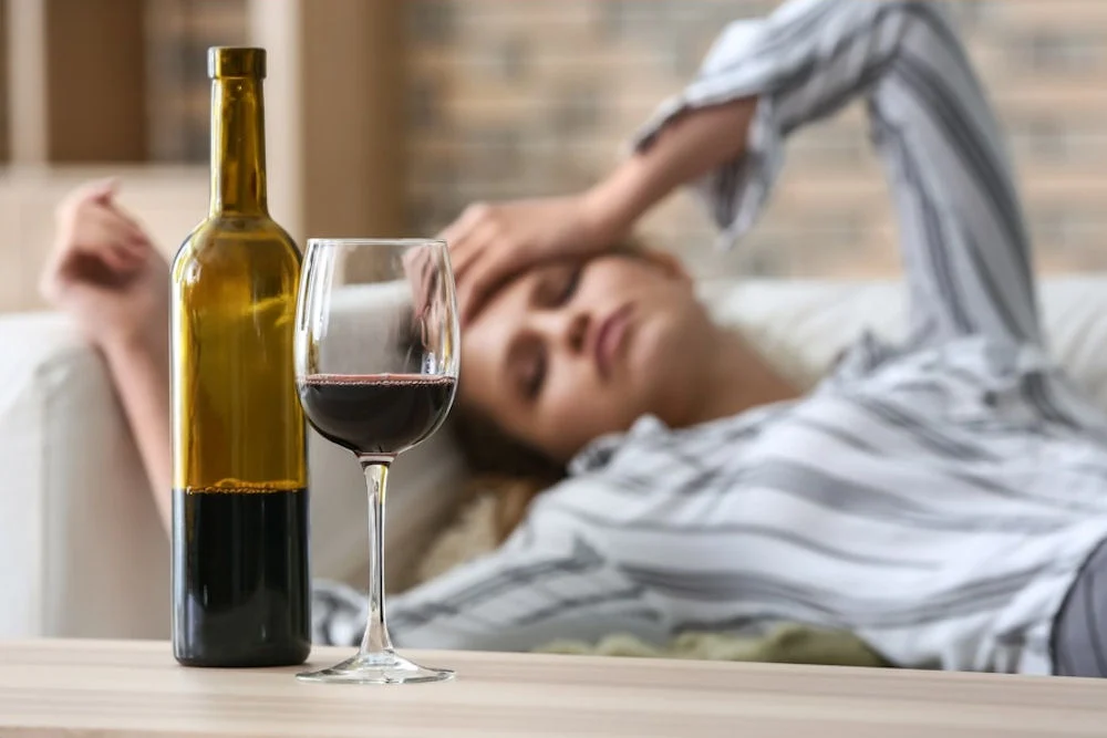 a woman with hands on head with glass of wine