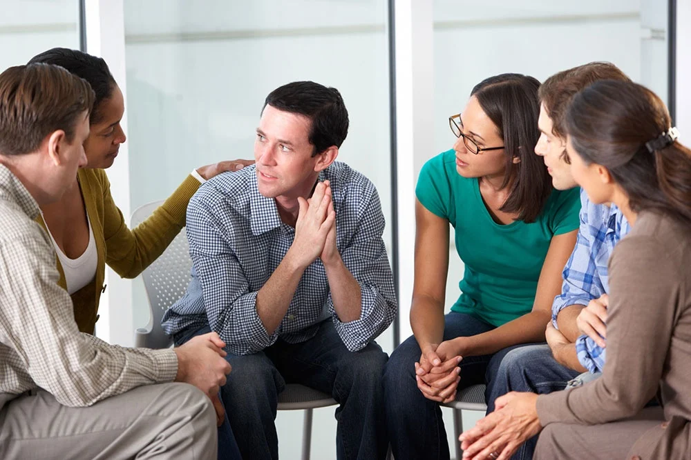 a group of individuals comforting a man at a rehab center in Pennsylvania