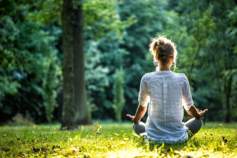 Individual practicing yoga outdoors in her backyard