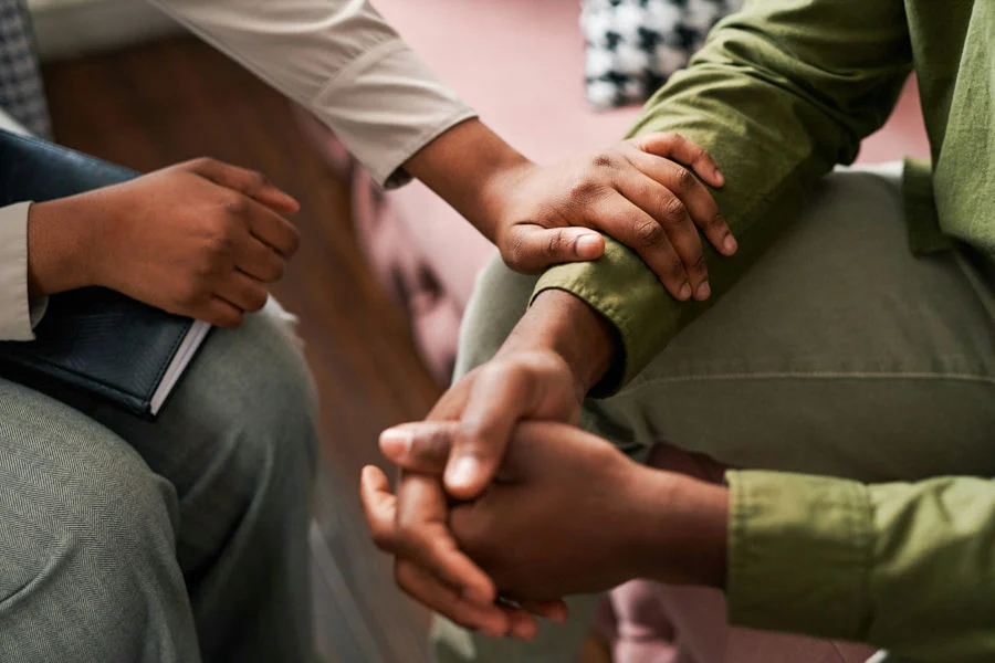 a woman comforting a man in therapy session
