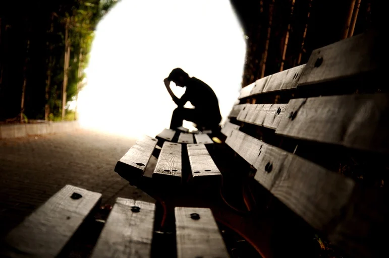 Person sitting on a bench, having depression