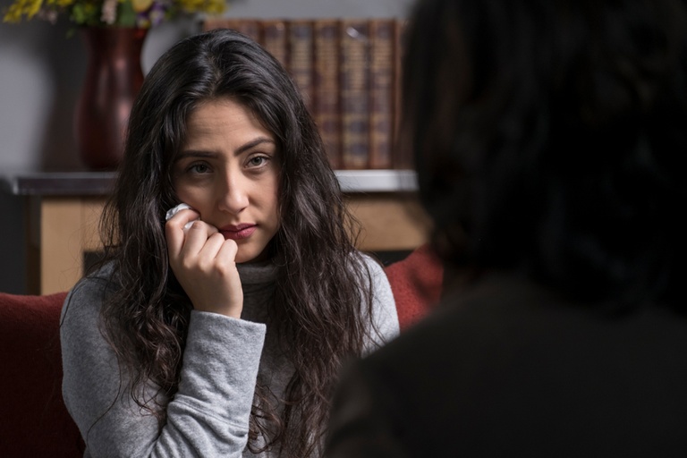 A woman listening to her therapist explain the stages of drug and alcohol withdrawal symptoms