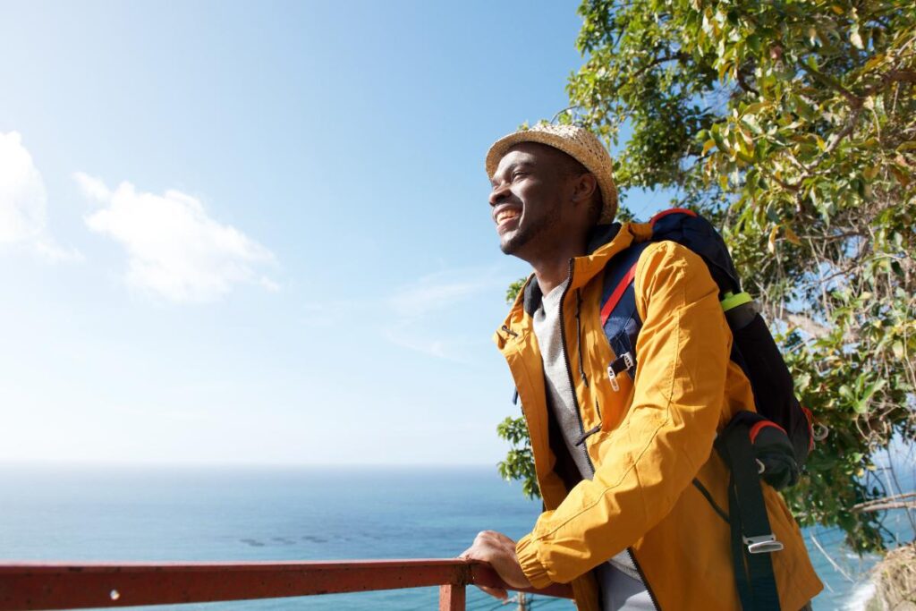 Man in yellow jacket looking at the ocean, reflecting on 3 reasons to start the New Year sober