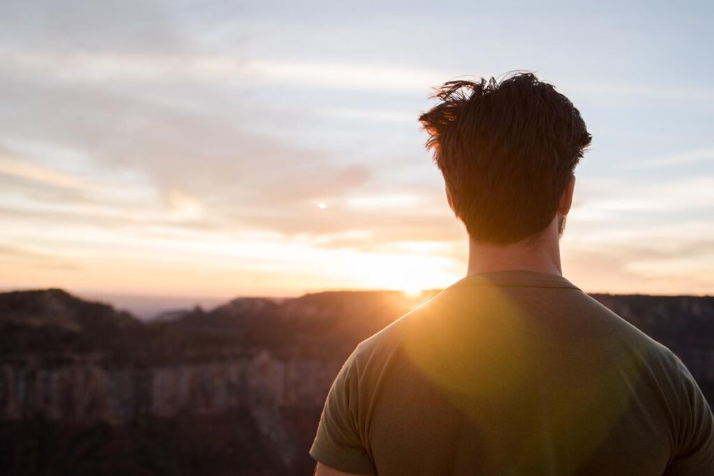 Male looking at a sunset, reflecting on 3 techniques to help with alcohol addiction