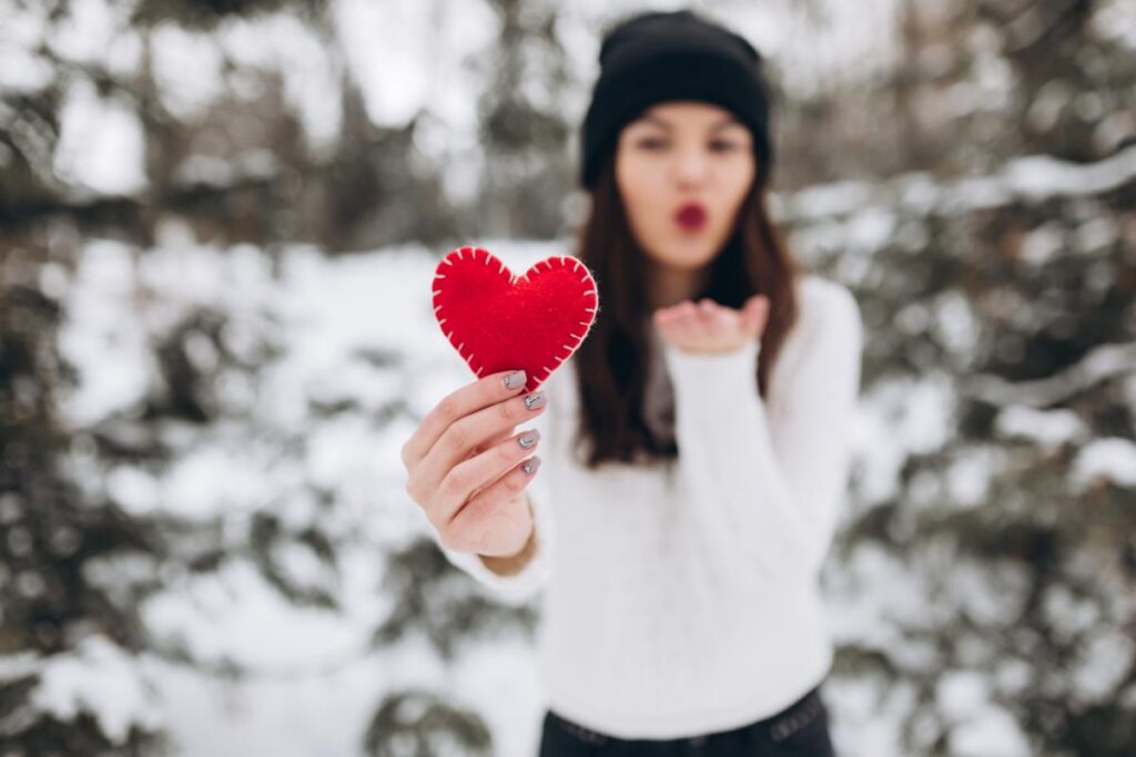 Girl holding a red heart, celebrating Valentine's Day sober