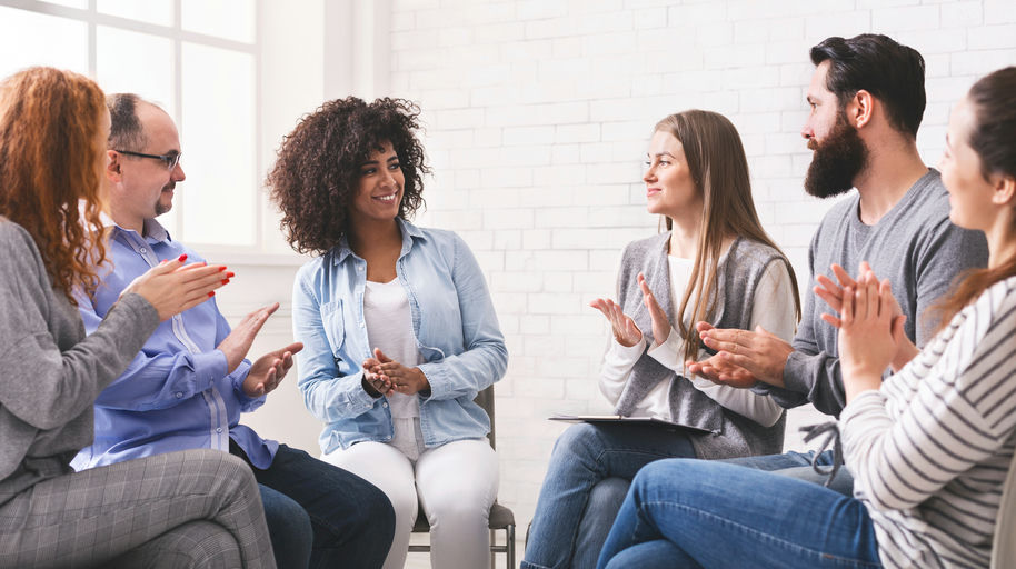 Therapist and individuals engaged in cognitive behavioral therapy session identifying thoughts and behaviors