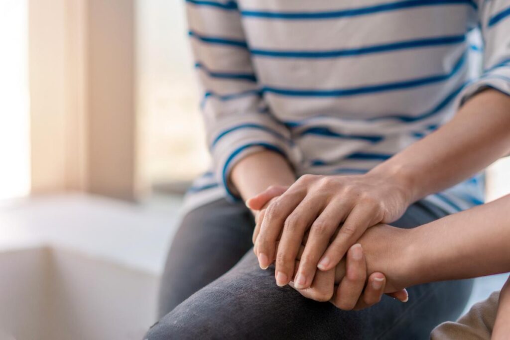 a pair of hands embraces another possibly during a dialectical behavior therapy for ptsd