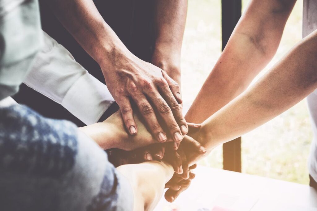 group of people putting their hands together in a circle in hopes of learning where to go for group therapy near lancaster pa