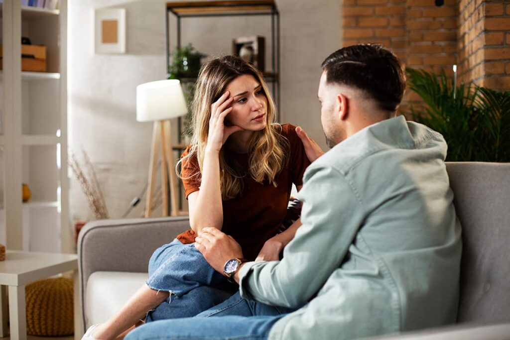 two people talk on a couch about the signs someone is addicted to painkillers