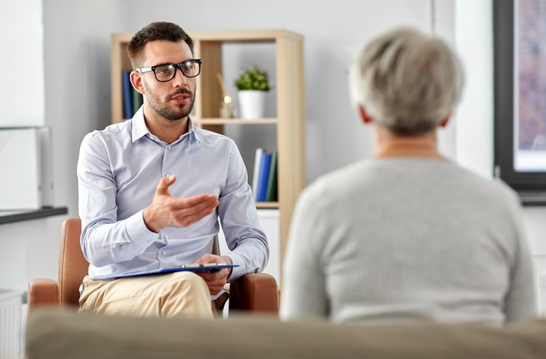 Therapist explaining signs of cocaine addiction: mood changes, dilated pupils, risky behavior