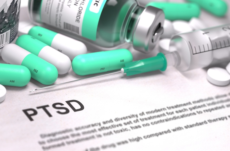 PTSD written on a white paper with capsules, an injection, and a vial